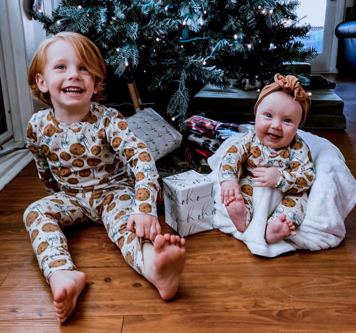 kids in christmas pajamas in front of tree